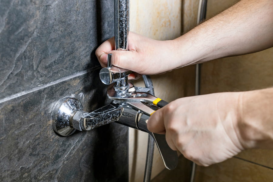 Plumber Fixing a Faucet with Wrench